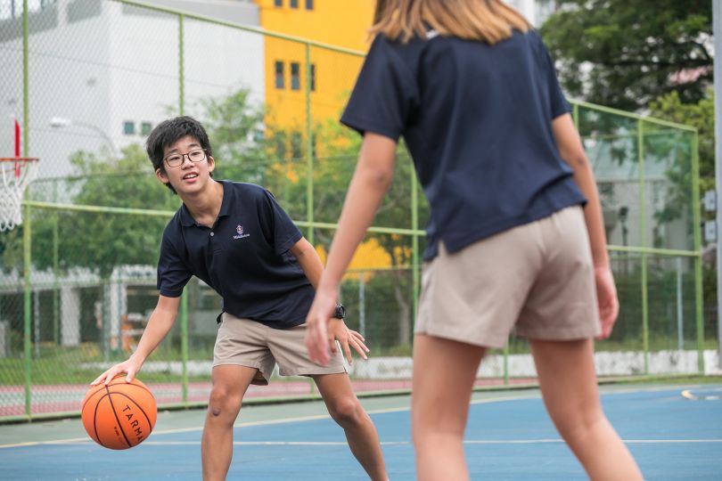 Students playing basketball on a school basketball court