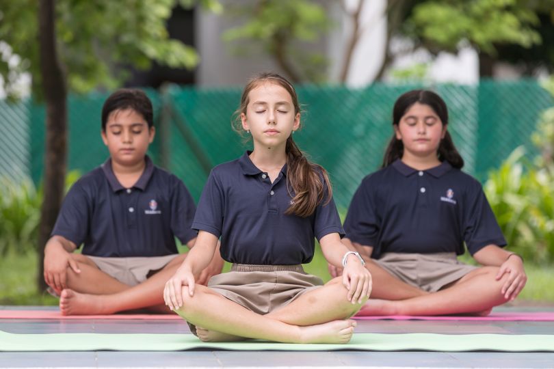 Students meditating on the school grounds